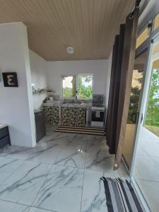 a kitchen with marble flooring in a house at Fare Hanihau in Uturoa
