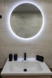 a bathroom with a sink and a circular mirror at maison de rivière in Afantou +19 photos