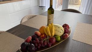 a plate of fruit on a table with a bottle of wine at Apartment Istra Mare private pool & parking in Ližnjan