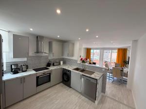 a kitchen with stainless steel appliances and a living room at Bella Apartment Playa Del Cura in Torrevieja
