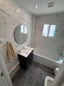 a white bathroom with a tub and a sink and a mirror at Bella Apartment Playa Del Cura in Torrevieja +2 photos
