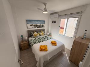 a bedroom with a bed with yellow towels on it at Bella Apartment Playa Del Cura in Torrevieja
