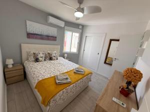 a bedroom with a bed and a table with towels on it at Bella Apartment Playa Del Cura in Torrevieja