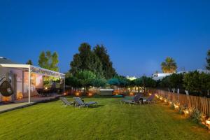 a lawn with chairs and lights in a yard at maison de rivière in Afantou