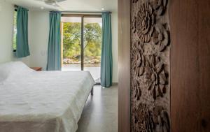 a bedroom with a bed and a large window at Area 101 in Playa Pelada +4 photos