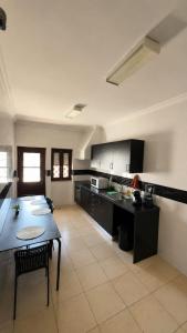 a large kitchen with a table and a dining room at Albani Hostel in Palmela