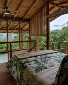 a bedroom with a bed in a room with windows at MindoLoft Loft de lujo con servicio premium en Mindo in Mindo