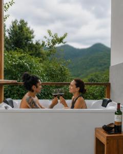two women sitting in a bath tub with a glass of wine at MindoLoft Loft de lujo con servicio premium en Mindo in Mindo +39 photos