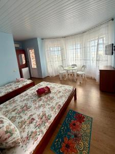 a bedroom with two beds and a table and chairs at Hotel Elion in Zatoka