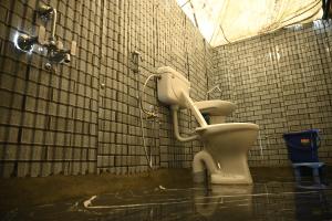 a bathroom with a toilet in a tiled wall at starry nights stay in Batakūt +98 photos