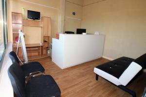 a living room with chairs and a counter with a tv at Hostel Marko in Tisno