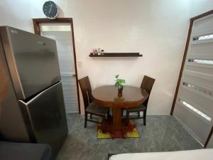 a kitchen with a small table and a refrigerator at Hermosa Traveler's Corner in Culis +5 photos