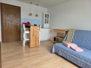 a living room with a blue couch and a kitchen at Apartament Gruba Foka in Hel +18 photos