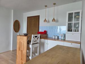 a kitchen with white cabinets and a wooden counter top at Apartament Gruba Foka in Hel