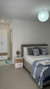 a bedroom with a large bed with a lamp on it at Kloa Apartments in Orikum