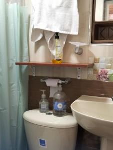 a bathroom with a toilet and a sink and towels at Hospedaje Patty Cajicá in Cajicá