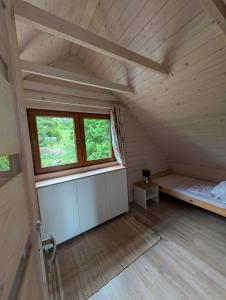 an attic room with a bed and a window at Sielski Domek Na Wzgórzu in Sulęczyno +9 photos