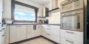 a kitchen with white cabinets and a window at Le Balzac - 2 Chambres - Balcon in Tours