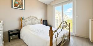 a bedroom with a white bed and a large window at Le Balzac - 2 Chambres - Balcon in Tours