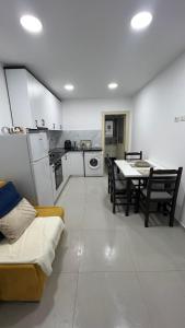 a kitchen and dining room with a table and a couch at Kloa Apartments in Orikum +2 photos