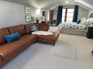 a living room with a brown couch and a bed at Loft on Blyth in Clyde