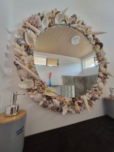 a mirror on a wall with shells on it at Fare Hanihau in Uturoa