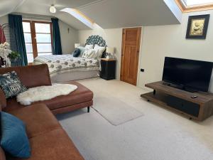 a living room with a couch and a flat screen tv at Loft on Blyth in Clyde
