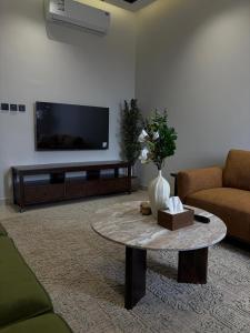 a living room with a tv and a coffee table at شقة غادة الفندقية الفاخرة in Abha