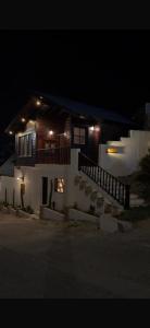 a house with a porch and a balcony at night at اكواخ اليمامة in Al Baha