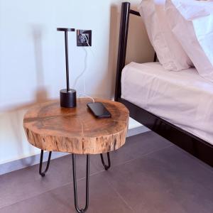a wooden table with a lamp on it next to a bed at LemonTreesHouses 1 Peaceful Stay Near Athens Airport & Rafina Port in Pikérmion