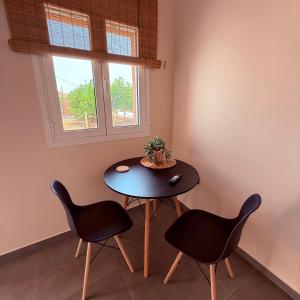 a table and two chairs in a room with a window at LemonTreesHouses 1 Peaceful Stay Near Athens Airport & Rafina Port in Pikérmion