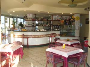 a restaurant with tables and a counter with a bar at Hotel ristorante cavallino in Cesenatico