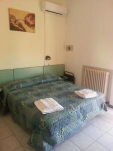 a bedroom with a bed with two towels on it at Hotel ristorante cavallino in Cesenatico