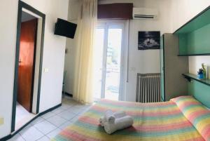 a bedroom with a bed with two towels on it at Hotel ristorante cavallino in Cesenatico