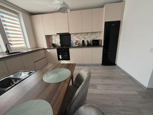 a kitchen with a wooden table and some chairs at Concept Residence in Târgu-Mureş