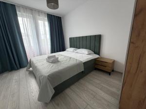 a bedroom with a bed and a large window at Concept Residence in Târgu-Mureş