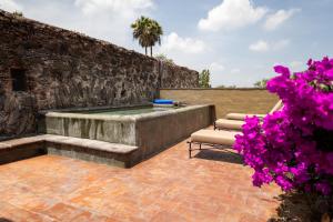 a patio with a hot tub and some purple flowers at Hacienda El Salitre Hotel & Spa in Querétaro