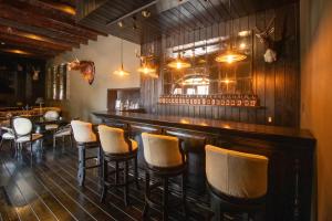 a bar with a row of bar stools at Hacienda El Salitre Hotel & Spa in Querétaro