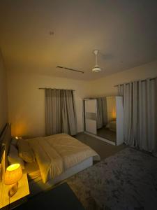a bedroom with a bed and a table and a mirror at غرف سكون Vip للأجار اليومي والاسبوعي in Al Khawḑ