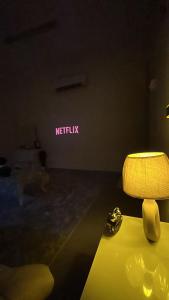 a dark room with a lamp and a neon sign at غرف سكون Vip للأجار اليومي والاسبوعي in Al Khawḑ
