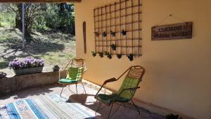 two chairs sitting outside of a house with a sign at Pousada Santa Rita in Amarantina