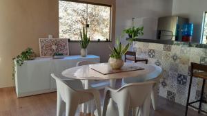 a kitchen with a table and chairs in a kitchen at Pousada Santa Rita in Amarantina