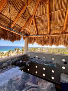 a resort pool with the ocean in the background at Condominio Agave del Mar in Coyuca