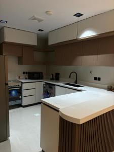 a large kitchen with a sink and a stove at شقة غادة الفندقية الفاخرة in Abha
