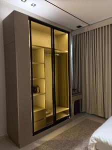 a bedroom with a large glass cabinet with shelves at شقة غادة الفندقية الفاخرة in Abha