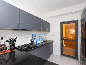 a kitchen with gray cabinets and a stove top oven at Chui de eagle in Mombasa
