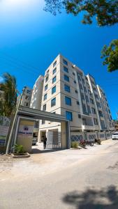 a large white building with people standing in front of it at Chui de eagle in Mombasa