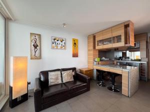 a kitchen and living room with a couch and a table at Oceana Suites Costa Montemar in Concón
