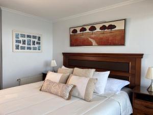 a bedroom with a large white bed with white pillows at Oceana Suites Costa Montemar in Concón