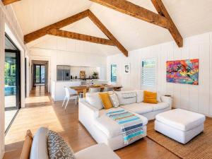 a living room with a white couch and a table at Blackpool Boathouse - Stay Waiheke in Oneroa